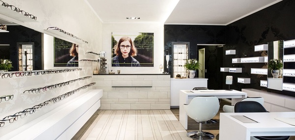 Modernes Optikergeschäft mit Brillenregalen, Beratungstischen und stilvoller Einrichtung.